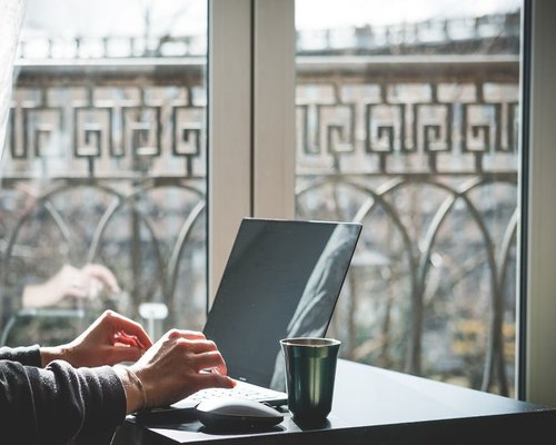 person working on a laptop beside a bright window in Mexico